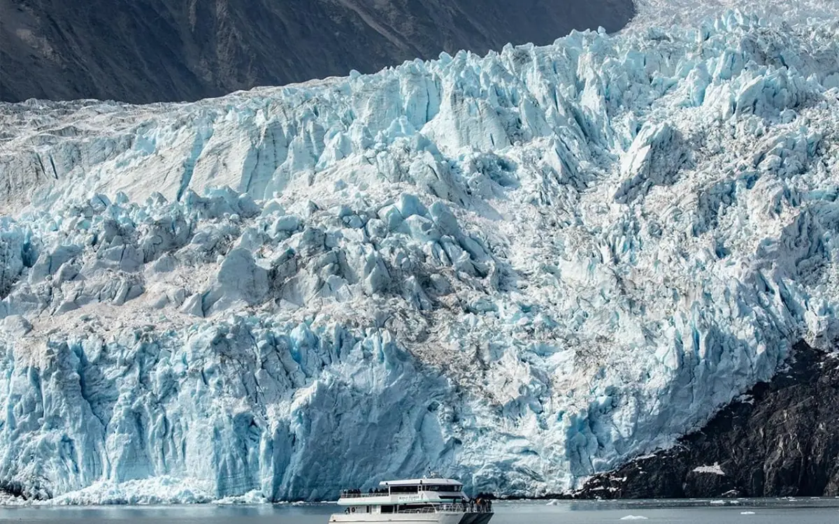 The bow of a tour boat pointed at a glacier in Kenai Fjords National Park