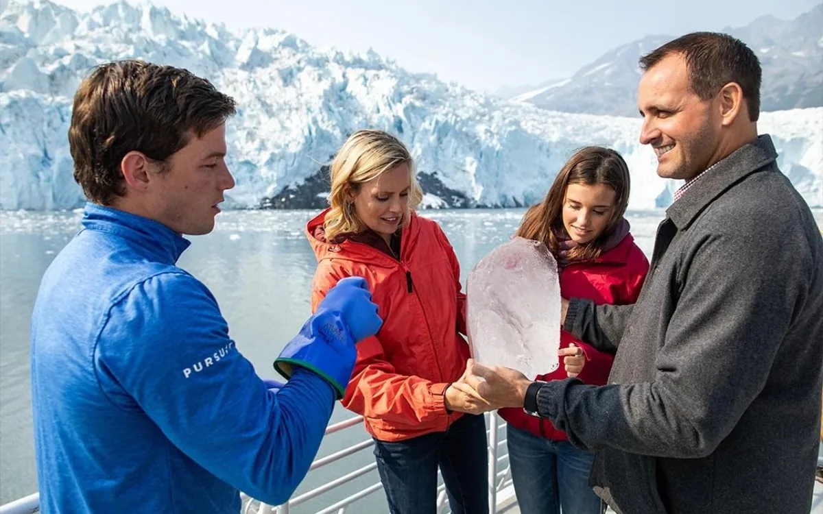 Una familia en la cubierta de un barco turístico observando un glaciar en Alaska
